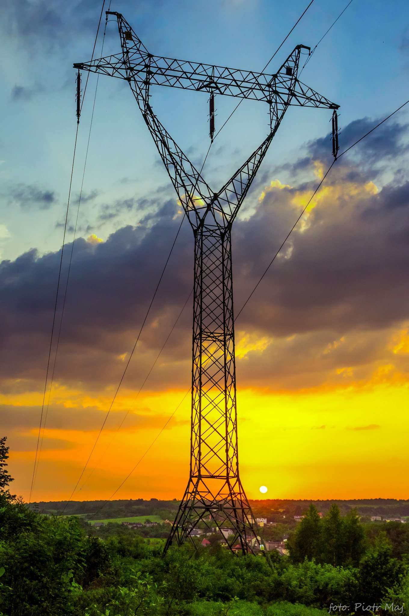 Charakterystyczny słup energetyczny na tle zachodu słońca w Grodźcu